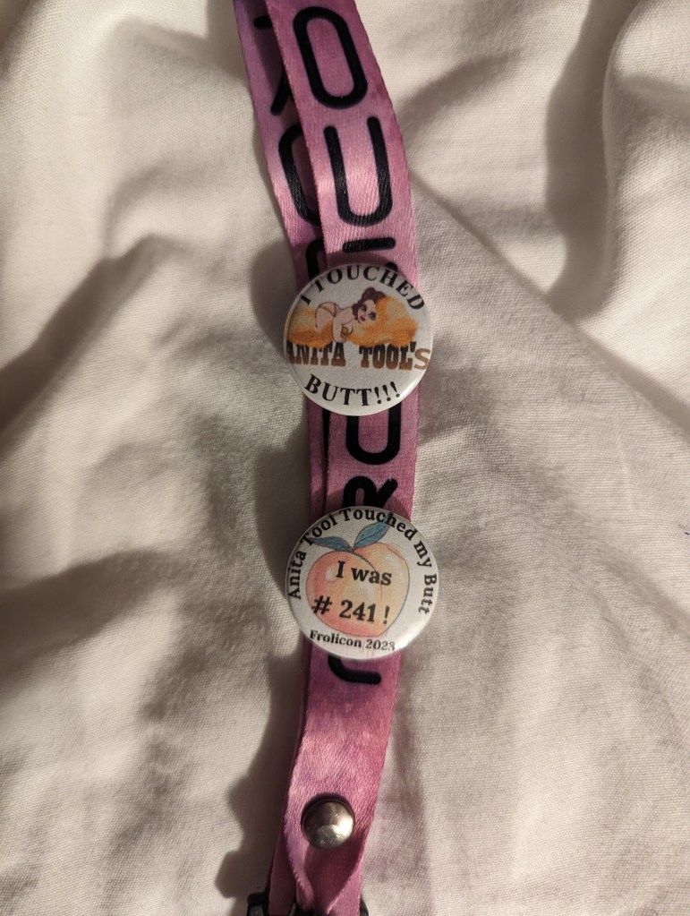 The lanyard for my Frolicon badge with two buttons on it. Top: "I touched Anita Tool's Butt!!!"; Bottom: "Anita Tool touched my butt -- I was #241!"