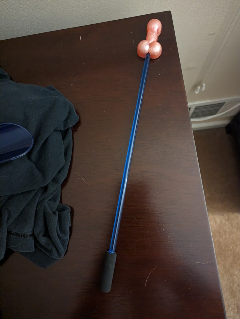 The "Dick Stick" -- a pink epoxy resin penis shape, about two or three inches long, attached to a blue rod. It leaves penis-shaped prints on skin.