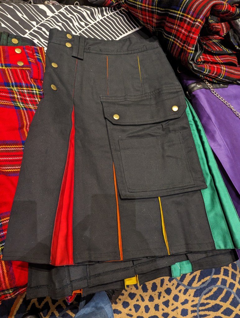 A black pleated kilt, the pleats in rainbow colors.