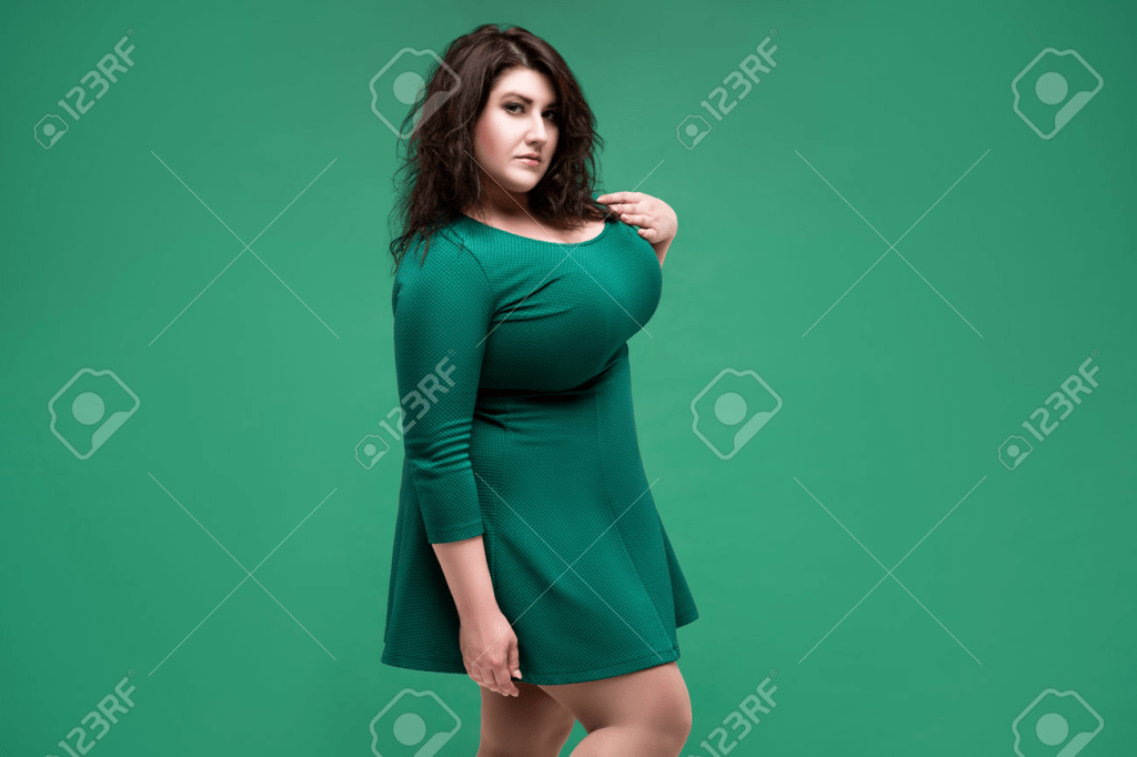A very curvy brunette in a green dress.